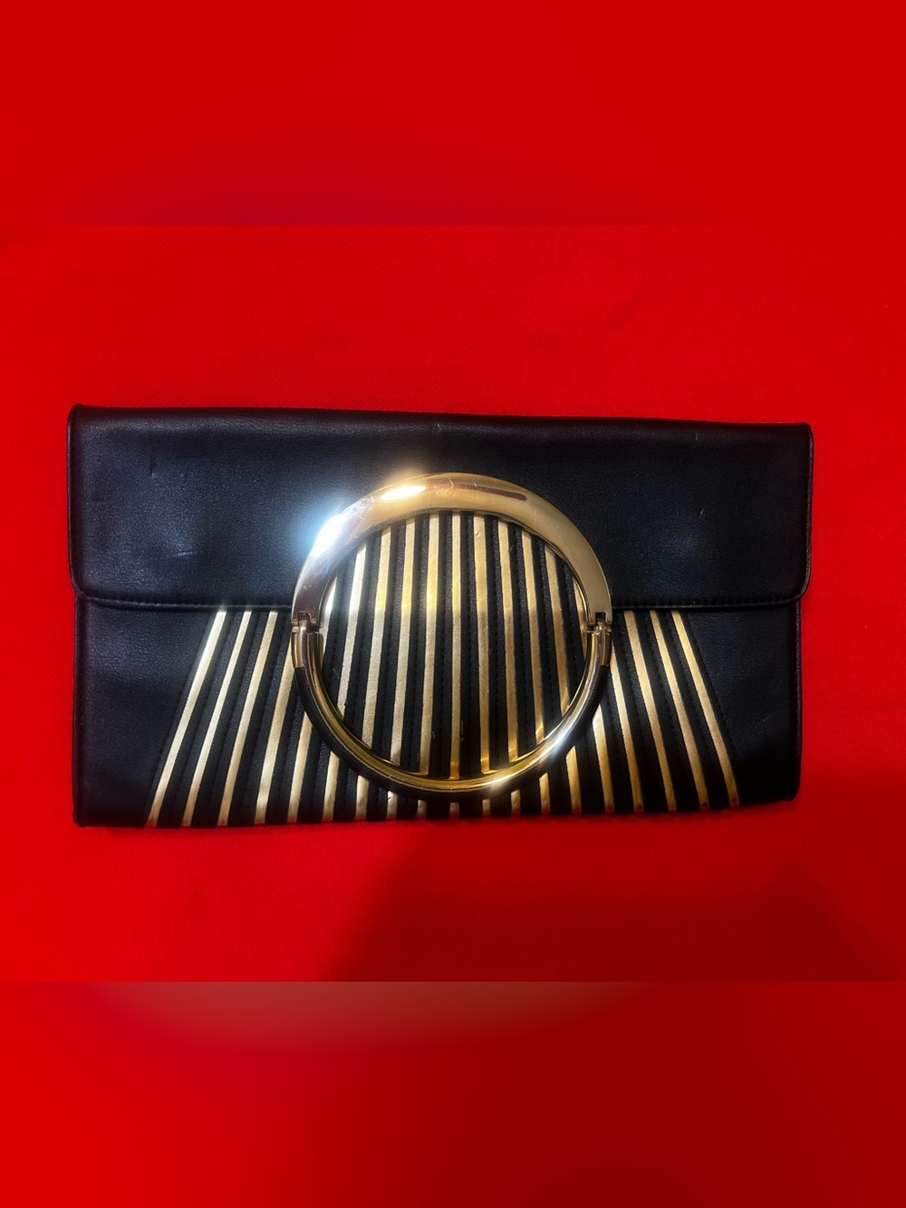 bebe faux leather Black Clutch with Gold Ring and Striped Accent